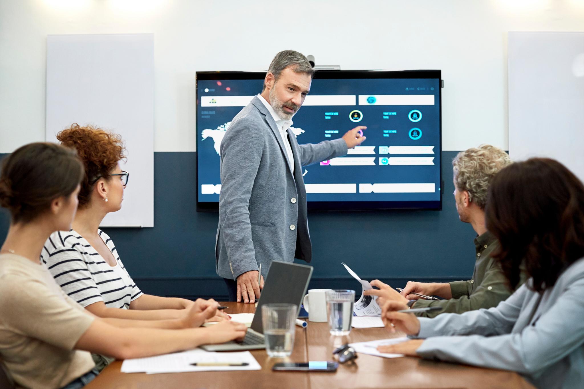 Businessman explaining infographic to partners